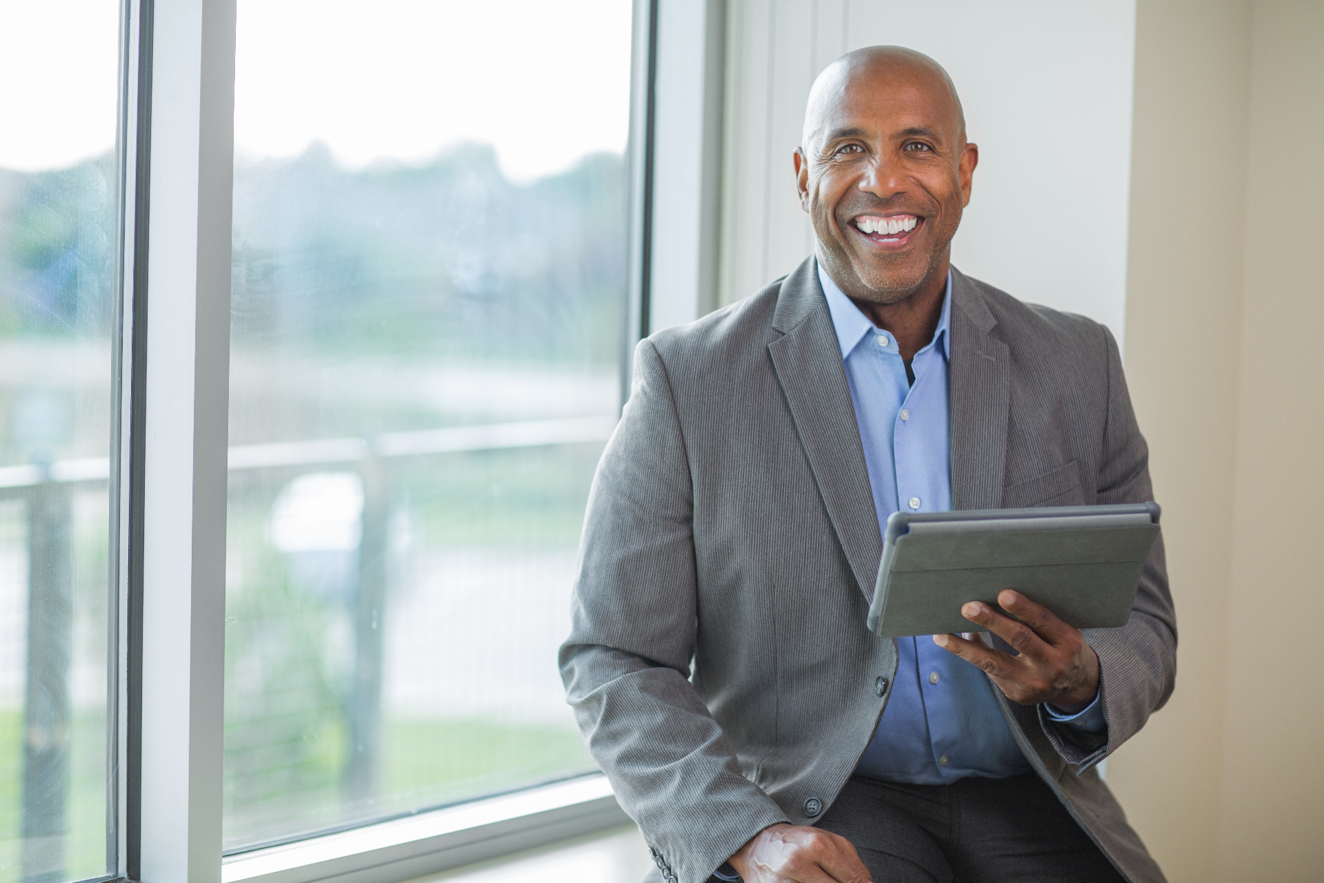 Confident senior professional with tablet in a modern office setting