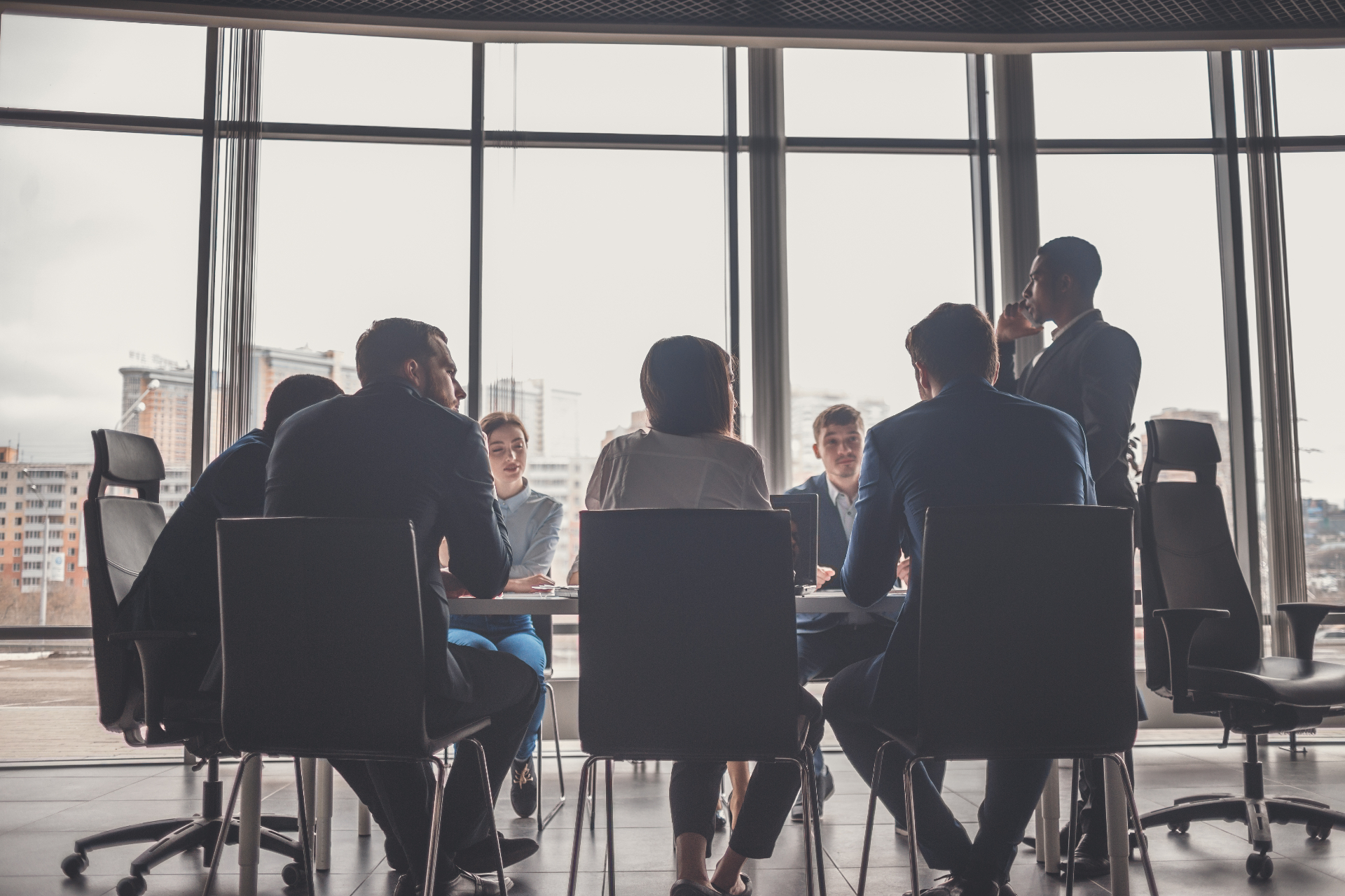 Executive team in a glass-walled boardroom — backdrop for senior buyer personas